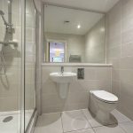 Modern bathroom with shower, sink, and toilet.