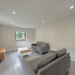Modern living room with grey sofas and wooden furniture.