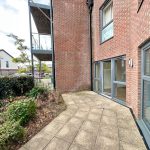 Brick building with patio and garden area.