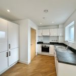Modern kitchen with white cabinets and wooden floor
