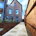 Modern brick building with wooden fence and path.