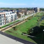 Modern housing estate with green spaces and paths.