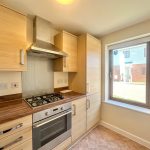 Modern kitchen with oven, hob, and sunny window.