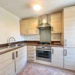 Modern kitchen with wooden cabinets and stainless steel appliances.
