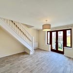 Bright living room with staircase and patio doors.