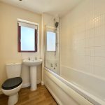 Modern white bathroom with bathtub and shower.