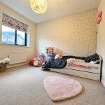 Cosy children's bedroom with toys and single bed.