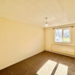 Empty room with window and carpet flooring.