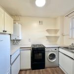 Small kitchen with appliances and white cabinets.