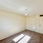 Empty room with beige walls and carpet floor.