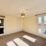 Bright empty room with carpet and French doors.