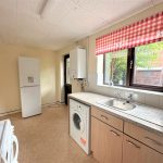Spacious kitchen with appliances and window view.