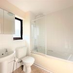 White modern bathroom with shower and toilet.