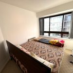 Bright bedroom with large window and double bed.