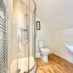 Modern bathroom with shower, toilet, and basin.