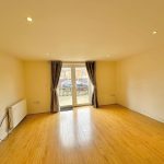 Empty room with wooden floor and French doors.