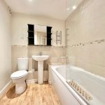 Modern bathroom with bathtub, toilet, and sink.