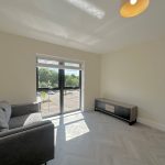 Bright room with sofa, large window, and cabinet.