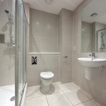 Modern bathroom with shower, toilet, and sink.