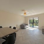 Modern living room with dining table and large window.
