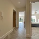 Modern flat hallway with wood flooring.
