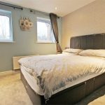 Cosy bedroom with double bed and wall decor.