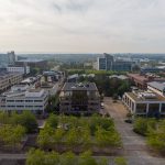 Aerial view of modern cityscape with buildings and trees.