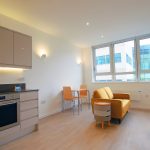 Modern studio flat with kitchen, dining and seating area.