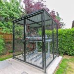 Secure outdoor bike storage cage with bicycles inside.