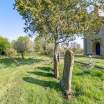 Historic churchyard with gravestones and trees.