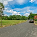 Scenic countryside road with houses and greenery.