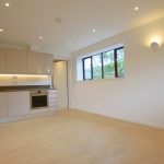 Modern kitchen with light wood flooring and cabinets.