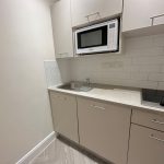 Modern kitchenette with microwave and hob.