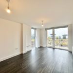 Bright apartment room with dark wooden floor.