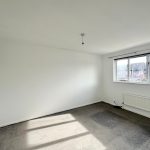 Empty room with large window and natural light.