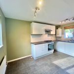 Modern kitchen with white cabinets and appliances.