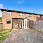 Brick house with patio and garden fence.