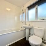 Modern bathroom with bath, sink, and toilet.