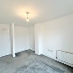 Empty room with grey carpet and white walls.