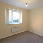 Empty room with window and beige walls.