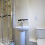 Modern bathroom with shower, sink, and toilet.