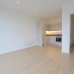 Modern empty kitchen interior with wood flooring.