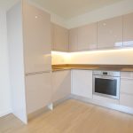 Modern kitchen with built-in appliances and sleek cabinets.