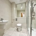 Modern bathroom with shower, sink, and toilet.