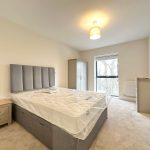 Bright bedroom with bed, wardrobe, and window view.