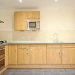 Modern kitchen with wooden cabinets and appliances.