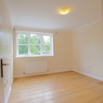 Empty room with wooden floor and window view.