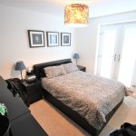 Modern bedroom with double bed and decor.