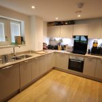 Modern kitchen with light wood flooring and cabinets.