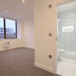 Modern flat interior with bathroom and large window.